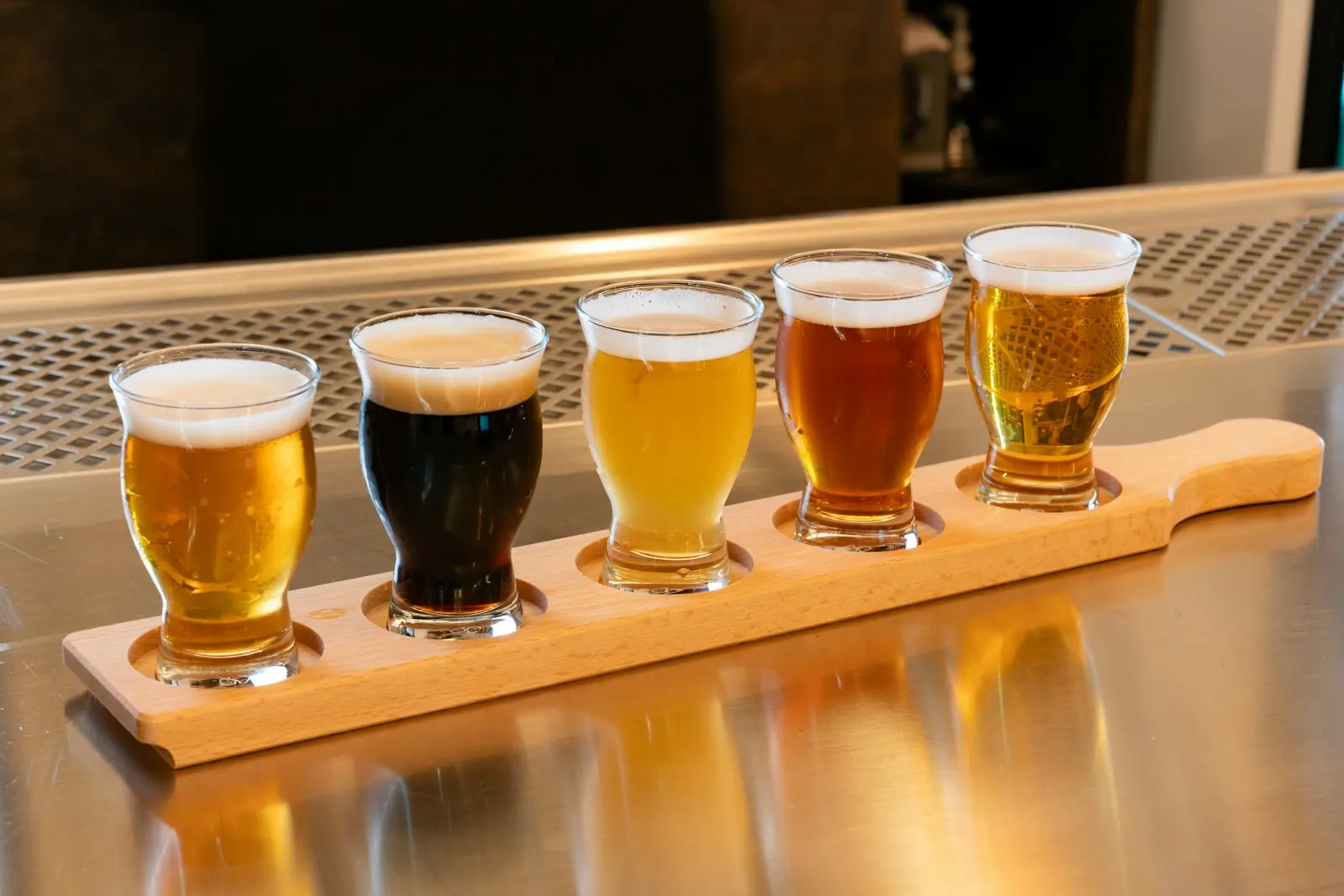 Vassoio di legno con cinque assaggi di birre di colori diversi