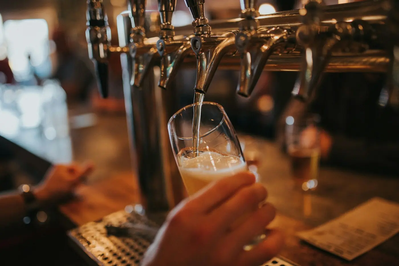 Birra chiara spillata da una colonna di spine in un pub